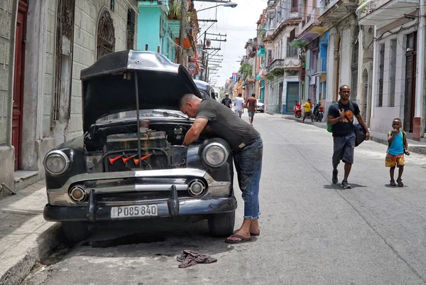 Хавна, Куба - 30 апреля 2017 года; Мужчина ремонтирует свою машину на улице — стоковое фото