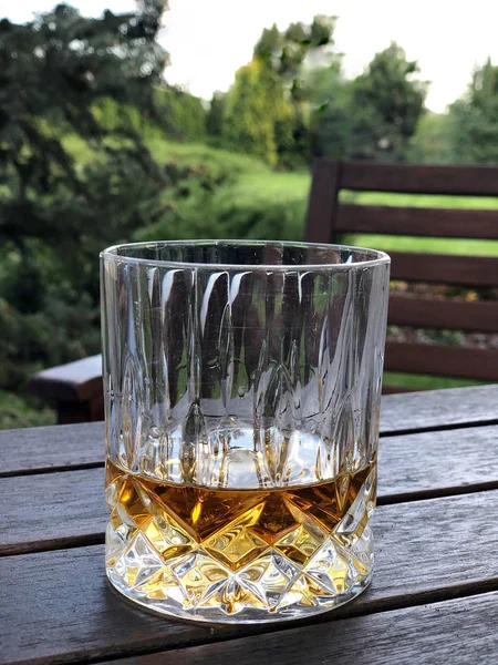 Um copo de uísque na mesa no jardim — Fotografia de Stock
