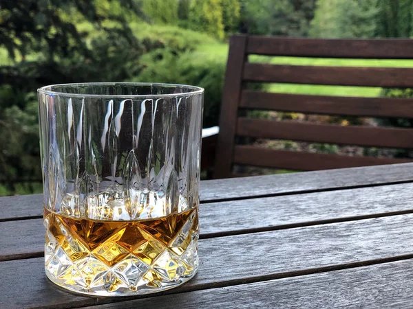 A glass of whiskey on table at garden — Stock Photo, Image