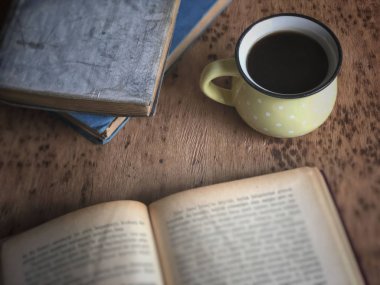 ahşap masa üzerinde kahve ve eski kitaplar bir fincan
