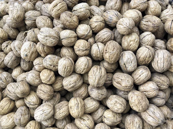 Whole walnuts with shells as a background — Stock Photo, Image