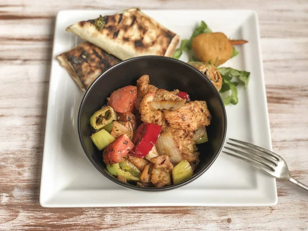 sweet and sour chicken and some side dish on table