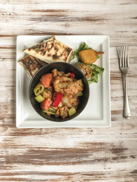 sweet and sour chicken and some side dish on table