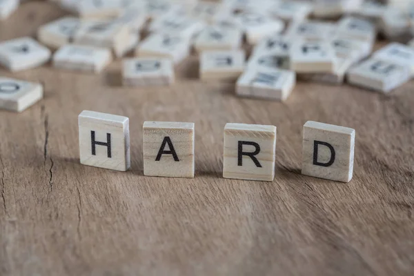 The word hard written with cube letters on wood — Stock Photo, Image