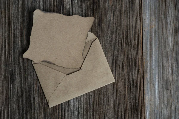 Une lettre vierge et une enveloppe sur une table en bois avec espace de copie — Photo