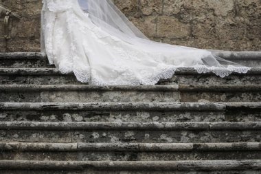 Düğün merdivenleri üzerinde kayma bir gelin ve gelinlik peçe