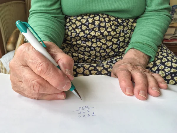 Fechar as mãos de uma mulher sênior escrevendo — Fotografia de Stock