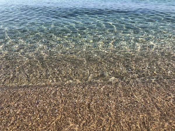 Ein klares Meer auf einem Sandstrand als Hintergrund — Stockfoto