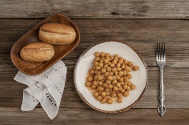 ahşap bir masada nohut ve ekmek bir tabak