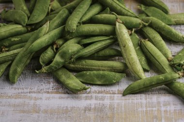 ahşap bir masa üzerinde taze bütün bezelye