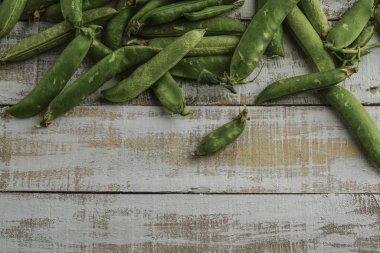 ahşap bir masa üzerinde taze bütün bezelye
