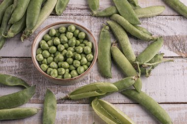 ahşap bir masa üzerinde taze çiğ bezelye