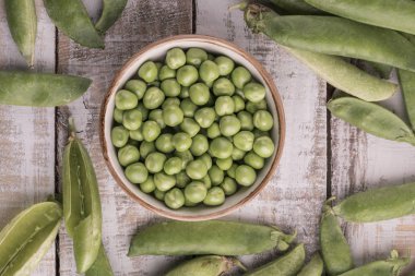 ahşap bir masa üzerinde taze çiğ bezelye