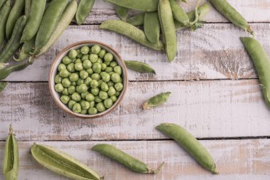ahşap bir masa üzerinde taze çiğ bezelye