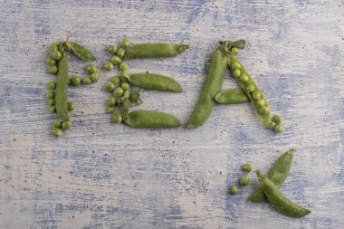 ahşap bir masa üzerinde taze çiğ bezelye