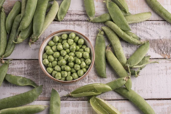 Verse rauwe erwten op een houten tafel — Stockfoto