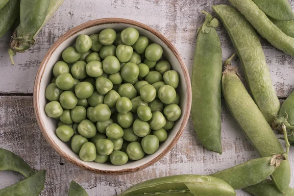 Verse rauwe erwten op een houten tafel — Stockfoto