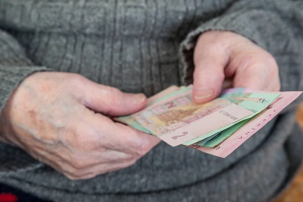 Крупный план морщинистых рук пожилого человека, считающего украинского громилу — стоковое фото