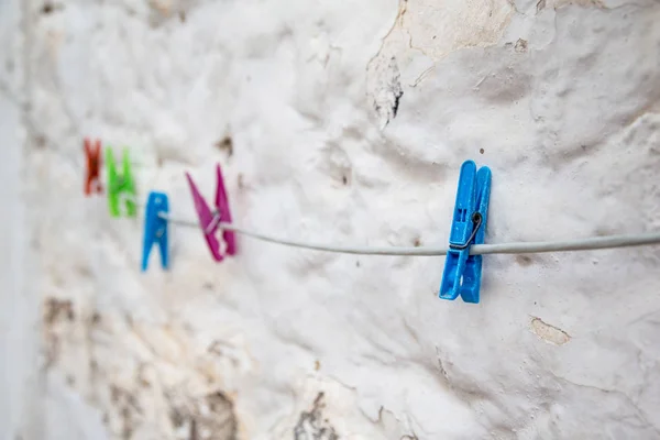 Bunte Wäscheklammern am Seil gegen Wand — Stockfoto