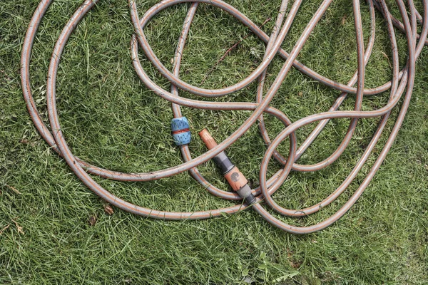 Schlauch auf Gras im Garten — Stockfoto