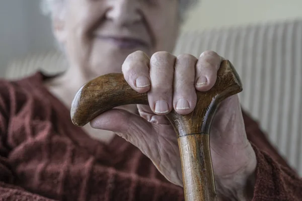 Gros plan main d'une femme âgée tenant bâton — Photo