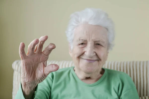 Una mujer mayor como si estuviera sosteniendo algo — Foto de Stock