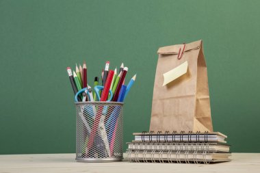 gre üzerinde kırtasiye ve öğle yemeği çantası ile okul şablonu geri