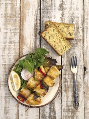 Masada salata ve mısır ekmeği ile servis edilen çarpık tek balık