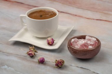 Güllerle süslenmiş bir masada Türk lokumu ve kahvesi