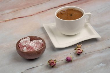 Güllerle süslenmiş bir masada Türk lokumu ve kahvesi