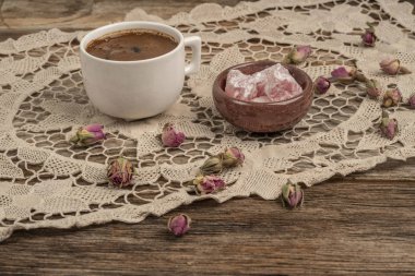 kurutulmuş gül fl ile dekore edilmiş masada kahve ve türk lokumu