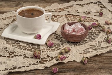 kurutulmuş gül fl ile dekore edilmiş masada kahve ve türk lokumu