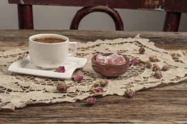 kurutulmuş gül fl ile dekore edilmiş masada kahve ve türk lokumu