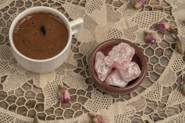 kurutulmuş gül fl ile dekore edilmiş masada kahve ve türk lokumu
