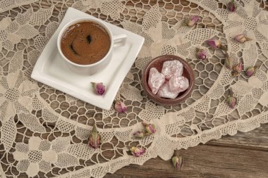 kurutulmuş gül fl ile dekore edilmiş masada kahve ve türk lokumu