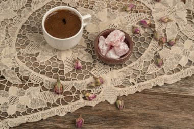 kurutulmuş gül fl ile dekore edilmiş masada kahve ve türk lokumu