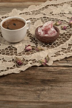 kurutulmuş gül fl ile dekore edilmiş masada kahve ve türk lokumu