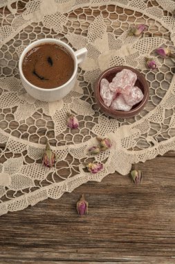 kurutulmuş gül fl ile dekore edilmiş masada kahve ve türk lokumu