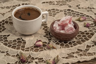 kurutulmuş gül fl ile dekore edilmiş masada kahve ve türk lokumu