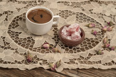 kurutulmuş gül fl ile dekore edilmiş masada kahve ve türk lokumu