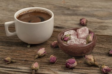 drie ile süslenmiş ahşap bir masada kahve ve türk lokumu