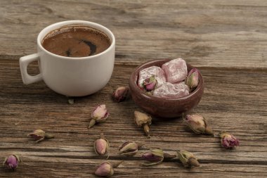 drie ile süslenmiş ahşap bir masada kahve ve türk lokumu
