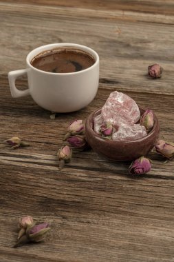 drie ile süslenmiş ahşap bir masada kahve ve türk lokumu