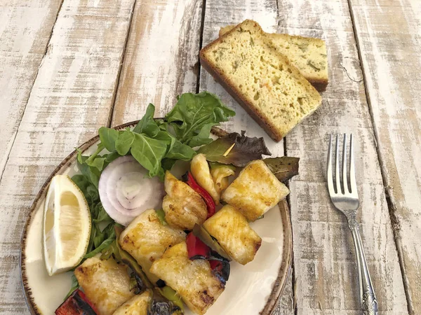 Pescado lenguado picado servido con ensalada y pan de maíz en la mesa —  Fotos de Stock