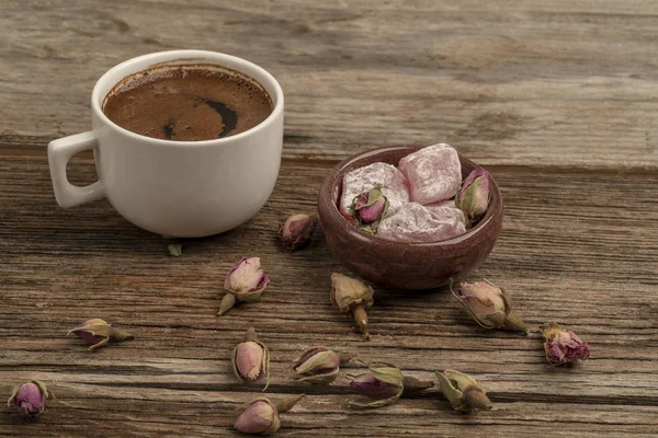 drie ile süslenmiş ahşap bir masada kahve ve türk lokumu
