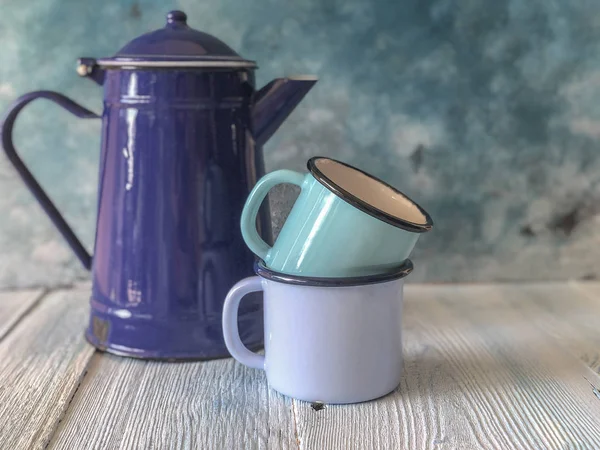 Blue colored enamel teapot and mugs on a wooden table — Stock Photo, Image