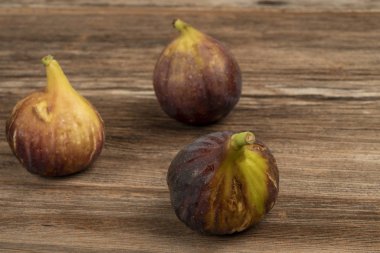 ahşap bir masa üzerinde taze ve olgun incir