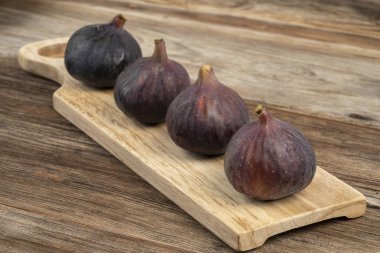 ahşap bir masa üzerinde olgun mor incir