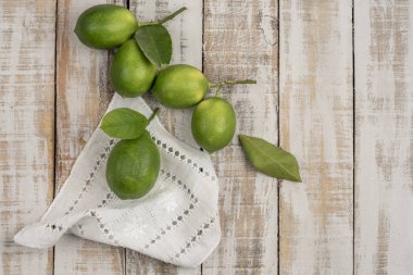 Tahta bir masada taze yeşil limon.