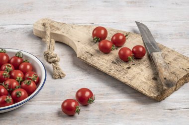 ahşap bir masada olgun kiraz domates ve bıçak